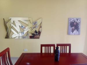 un tavolo con un vaso sopra in una stanza con dei quadri di ThandyTasha luxury apartments a Lusaka Altre 2 foto