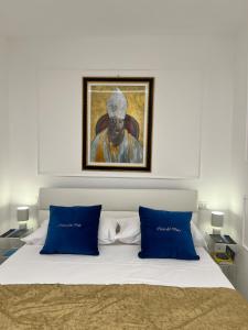 a bedroom with a bed with a painting above it at Casa Del Duca in Salerno +9 photos