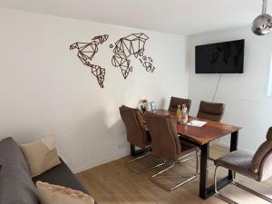Una sala de estar con una mesa y sillas de madera. en Moderne gemütliche Ferienwohnung in Friedrichshafen, en Friedrichshafen 10 fotos más