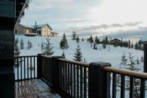 a balcony of a house with a snow covered yard at Log Cabin By Mostertoppen Ski Stadium in Hafjell