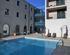 ein Schwimmbad vor einem Gebäude in der Unterkunft Hotel Lipa in Postira