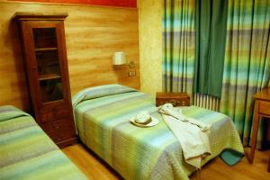 a bedroom with two twin beds and a table at Hotel Rural Bidean in Puente la Reina