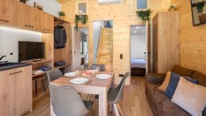 a dining room and living room with a table and chairs at Wendelstein Mountain Camp in Fischbachau