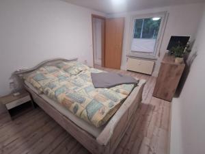 ein Schlafzimmer mit großem Bett und Fenster in der Unterkunft Am Wald der Sinne, EG in Buddenhagen