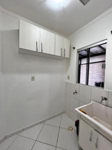 a kitchen with white cabinets and a sink at Casa ampla e confortável em Balneário Camboriú in Balneário Camboriú +37 photos
