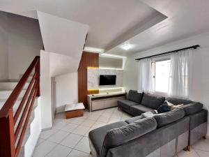 a living room with a couch and a television at Casa ampla e confortável em Balneário Camboriú in Balneário Camboriú