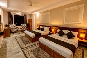 a hotel room with two beds and a living room at Hotel LAA Meridian, Har Ke Pauri Road - Haridwar in Haridwār