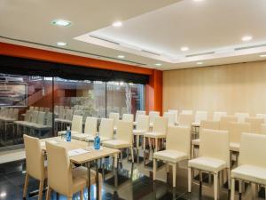a conference room with tables and white chairs at MIM Sitges Member of Melia Collection in Sitges