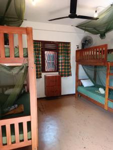 a room with two bunk beds and a window at Coco Mango Hostel in Hiriketiya