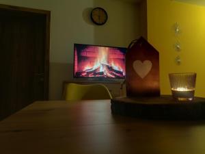 a room with a table with a tv in the background at Ferienwohnung Feuer im Ferienhaus am Waldbach in Kirchzell