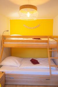 a bunk bed in a room with a yellow wall at Ferienwohnung Feuer im Ferienhaus am Waldbach in Kirchzell