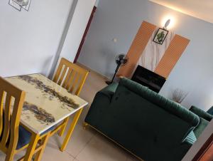 a living room with a green couch and a table at Kampala suites Kisementi in Kampala +7 photos
