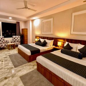 a hotel room with two beds and a window at Hotel LAA Meridian, Har Ke Pauri Road - Haridwar in Haridwār