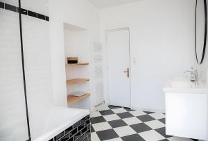 ein Badezimmer mit schwarz-weiß kariertem Boden in der Unterkunft La Maison De Famille in Luçon + 20 Fotos