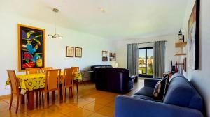 ein Wohnzimmer mit einer Couch und einem Tisch und Stühlen in der Unterkunft Charming Orada 2-Bedroom Albufeira Duplex Apartment with Shared Pool sleeps 6 in Páteo