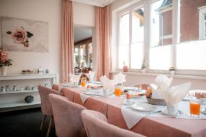 ein Esszimmer mit Tischen und Stühlen und Fenstern in der Unterkunft Hotel-Garni Haus Johanna in Einbeck