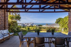 een houten tafel en stoelen op een terras bij 8 Tarbet Ness in Vosburg