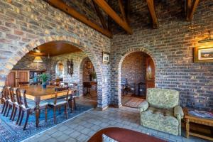 een woonkamer met een tafel en een bakstenen muur bij 8 Tarbet Ness in Vosburg