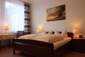 ein Schlafzimmer mit einem Bett und einem Baumgemälde an der Wand in der Unterkunft Hotel-Garni Haus Johanna in Einbeck