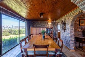 een eetkamer met een houten tafel en een bakstenen muur bij 8 Tarbet Ness in Vosburg +11 foto's