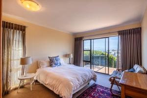 een slaapkamer met een bed en een groot raam bij 8 Tarbet Ness in Vosburg