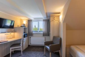 ein Hotelzimmer mit Schreibtisch und Bett in der Unterkunft Hotel-Garni Haus Johanna in Einbeck