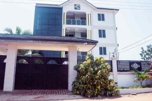 une maison blanche avec un garage noir dans l'établissement Sebrose Star Palace Hotel, à Hohoe
