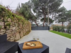 einen Tisch mit einem Teller Essen und zwei Gläsern Wein in der Unterkunft Villa La Marquesa - amplia, con patio y barbacoa in Ourense