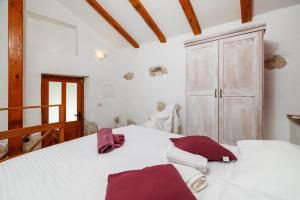 a bedroom with a white bed with purple towels on it at KUCA MARSSILI in Grižane +47 photos