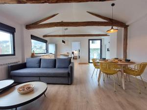 ein Wohnzimmer mit Sofa und Tisch in der Unterkunft Villa La Marquesa - amplia, con patio y barbacoa in Ourense