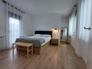 ein weißes Schlafzimmer mit einem Bett und einem Tisch in der Unterkunft Villa La Marquesa - amplia, con patio y barbacoa in Ourense