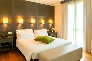 a bedroom with a large white bed with a green pillow at Villa Giorgia Albergo in Collina in Pistoia +42 photos