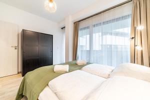 ein Schlafzimmer mit einem Bett und einem großen Fenster in der Unterkunft Tisza Terrace Apartman by Mital in Szeged + 19 Fotos