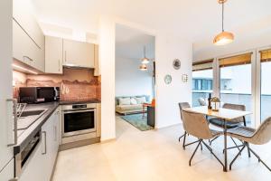 eine Küche und ein Esszimmer mit Tisch und Stühlen in der Unterkunft Tisza Terrace Apartman by Mital in Szeged