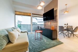 ein Wohnzimmer mit Sofa und Tisch in der Unterkunft Tisza Terrace Apartman by Mital in Szeged