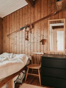 a bedroom with a bed and a chair and a mirror at Hytte I Uvdal Med Ski-Inout in Uvdal