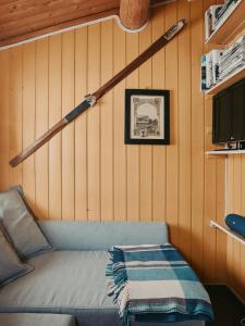 a couch in a room with a wall with a baseball bat at Hytte I Uvdal Med Ski-Inout in Uvdal