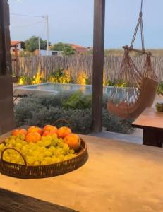 a basket of fruit sitting on a table next to a window at Maracangalha Beach Inn in Barra Grande