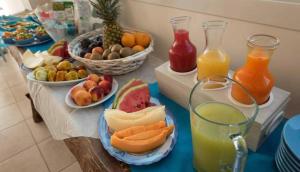 a table topped with plates of fruit and juice at The Twin Boutique Hotel in Torre Suda