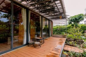 ein Glashaus mit zwei Hockern auf einer Holzveranda in der Unterkunft Sim Resort in Phu Quoc