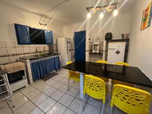 cocina con mesa y sillas amarillas en Casa vista Mar, pé na areia com piscina !, en Pitimbu