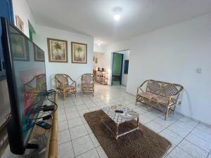 sala de estar con TV de pantalla plana y sillas en Casa vista Mar, pé na areia com piscina !, en Pitimbu
