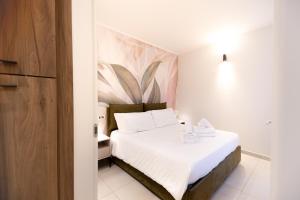 a bedroom with a white bed with a painting on the wall at Home Manu Luxury Como Lake in Como +10 photos