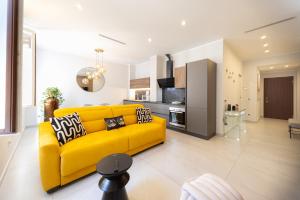 a living room with a yellow couch and a kitchen at Home Manu Luxury Como Lake in Como