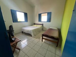 una habitación con una cama y una mesa y dos ventanas en Casa vista Mar, pé na areia com piscina !, en Pitimbu 50 fotos más