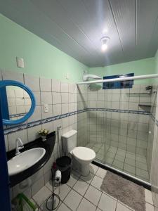 Un baño con inodoro, lavabo y ducha. en Casa vista Mar, pé na areia com piscina !, en Pitimbu