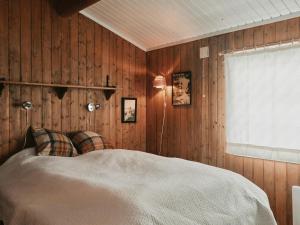 a bedroom with a bed with wooden walls and a window at Hytte I Uvdal Med Ski-Inout in Uvdal