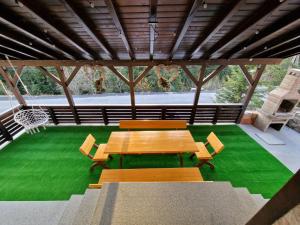 a table and chairs in a pavilion with green grass at Căsuța Alpină in Ranca