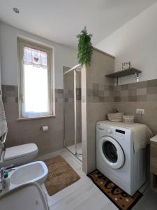 a bathroom with a washing machine and a shower at Angela apartments in Partinico