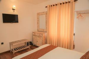 a bedroom with a bed and a dresser and a mirror at Grace in Nuwara Eliya